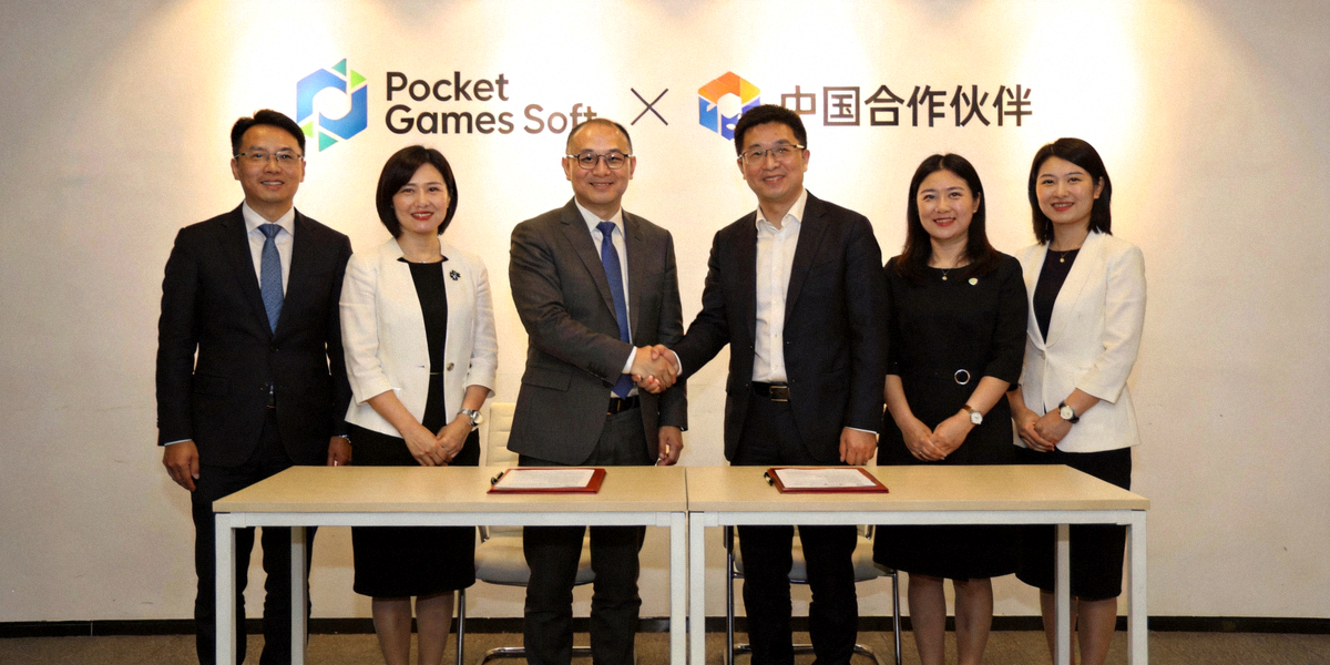 Pocket Games Soft与中国合作伙伴签约仪式现场 - 双方代表握手合影，背景为合作标识
